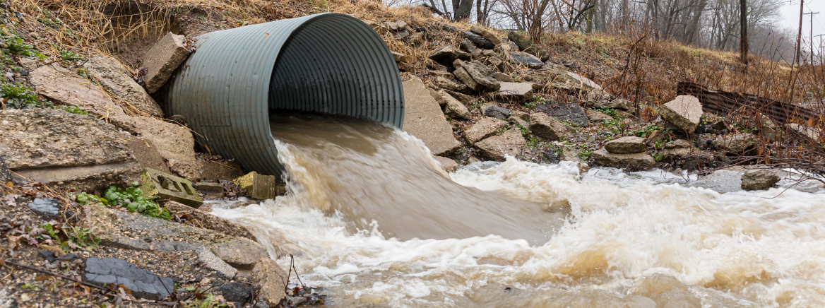 Luesa Homepage Header image of storm drain with water rushing out