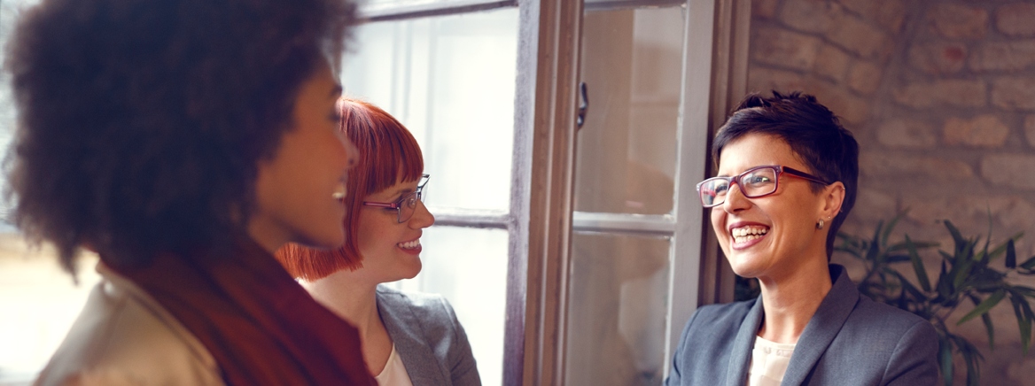 Three women sharing a conversation.