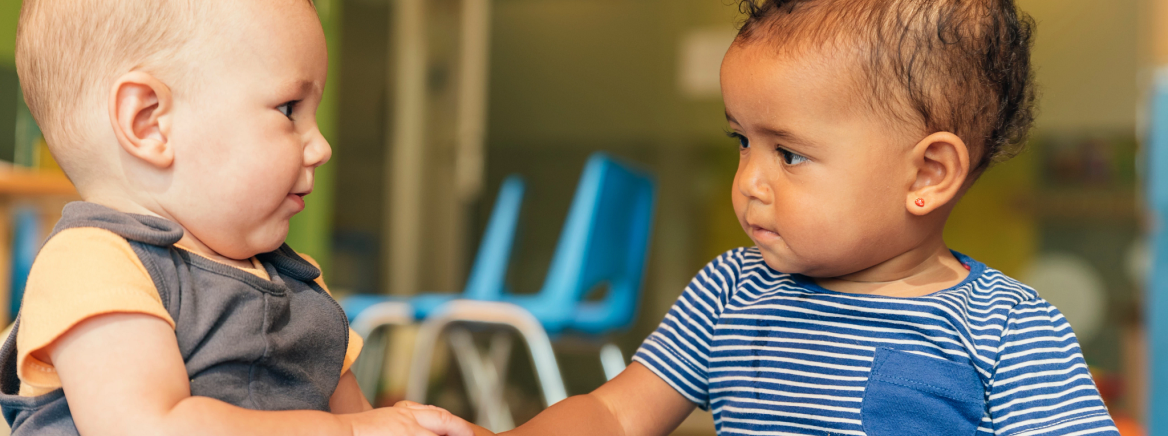 Two babies interacting at daycare