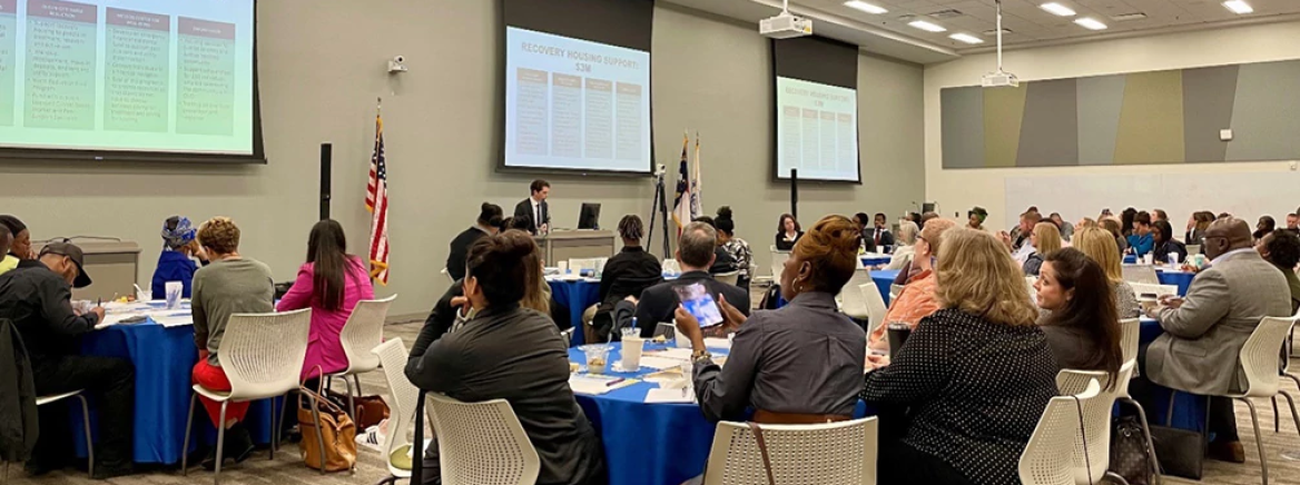 Opioid community engagement 2023 A group of community meetings sitting at tables in a large conference room