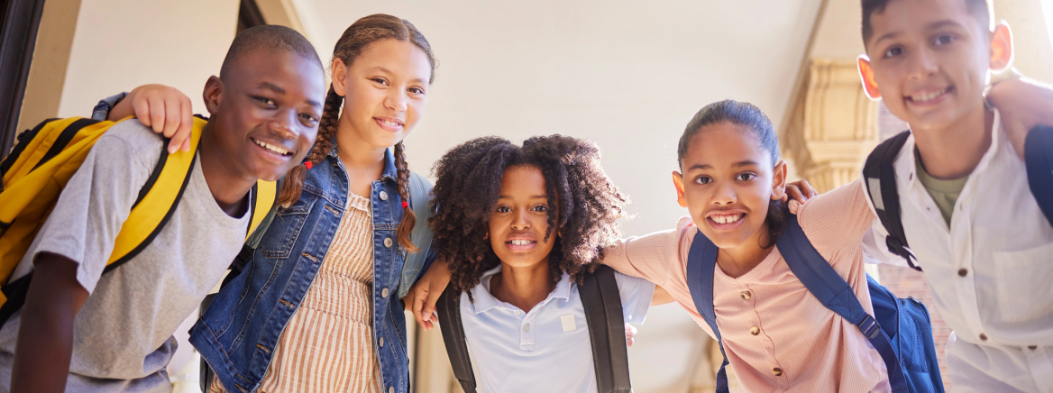 A diverse group of school friends wearing backpacks and smiling