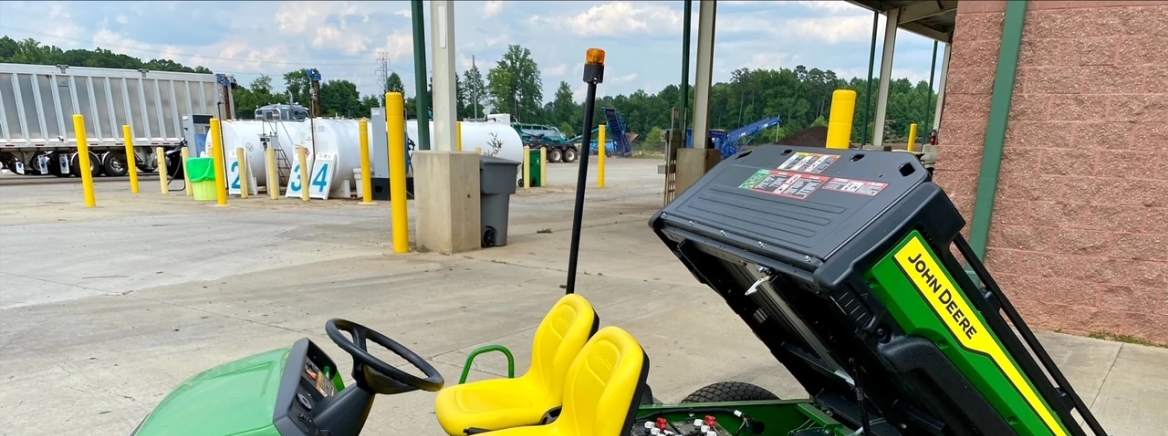 John Deere Gator A green John Deere electric Gator with yellow seats parked at Compost Central