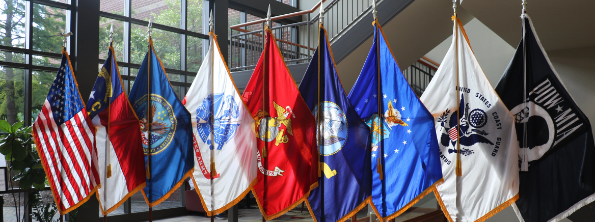 Flags United States and North Carolina flags along with various flags representing the armed forces.
