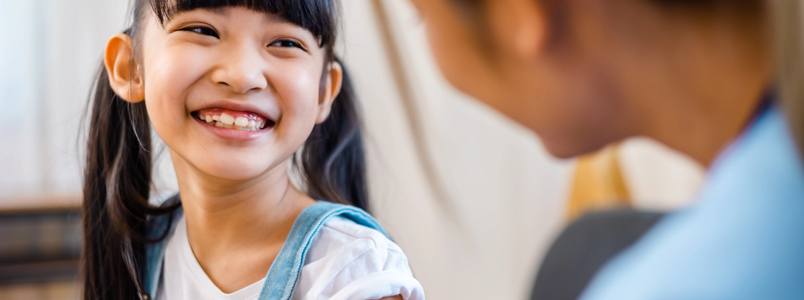 Student getting an immunization Childhood vaccination. Asian young woman doctor vaccinating little girl at home. Vaccine for covid-19 coronavirus, flu, infectious diseases.