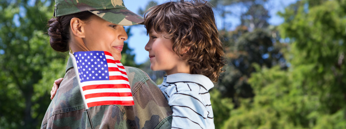 A female veteran with a young child holing an American flag