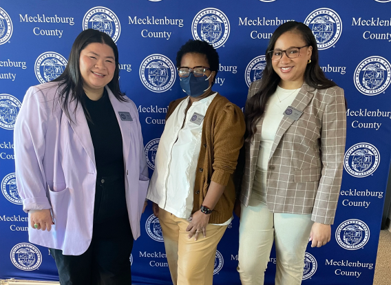 Public Information&#039;s Social Media team standing in front of a blue backdrop with the Mecklenburg County seal at the 2024 Social Media Summit. Left to right: Adison Le, Jameil Weldon and Hayley Belton