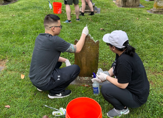 Volunteers clean a headstone at Settlers&#039; Cemetery.