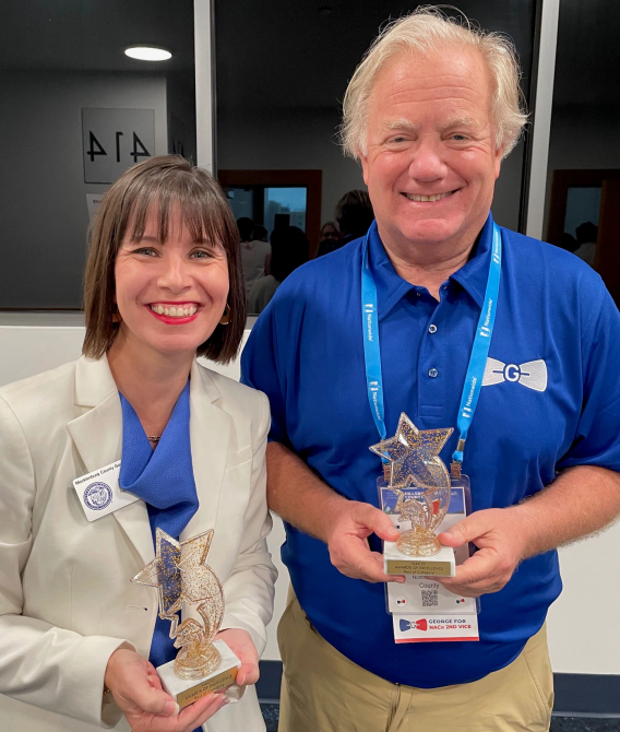 Public Information Officer Pam Escobar and Public Information Director Danny Diehl stand holding NACIO awards presented to the Public Information Department in July 2024.